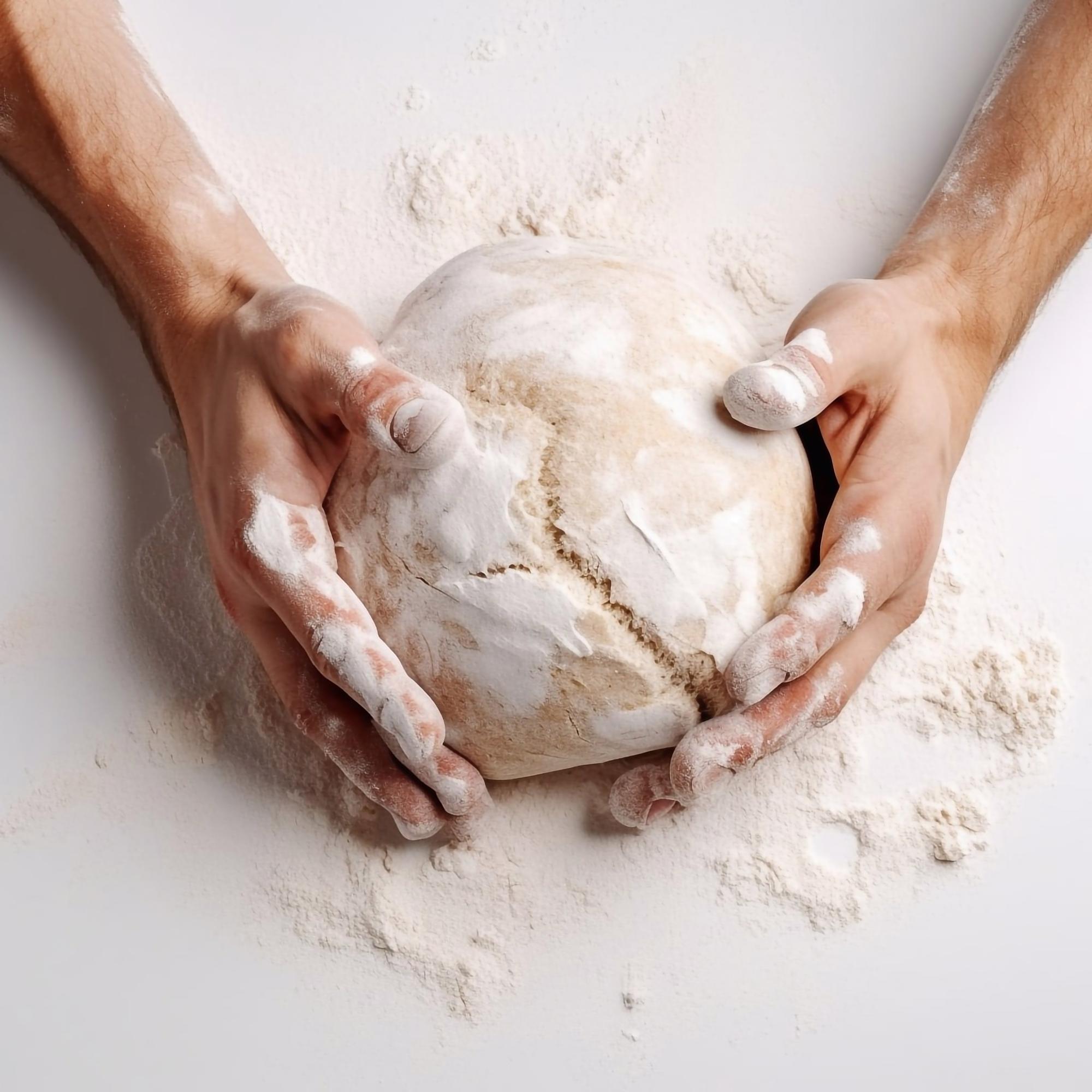 Dettaglio di mani che impastano una pasta fresca